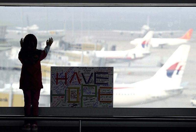A sign wishing for the safe return of passengers aboard Malaysia Airlines Flight 370 is displayed at the Kuala Lumpur International Airport shortly after the plane’s March 8 disappearance.