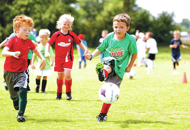 STAFF PHOTO JASON IVESTER Marshall Davis, 6, right, takes a shot Friday during the Soccer Camp.