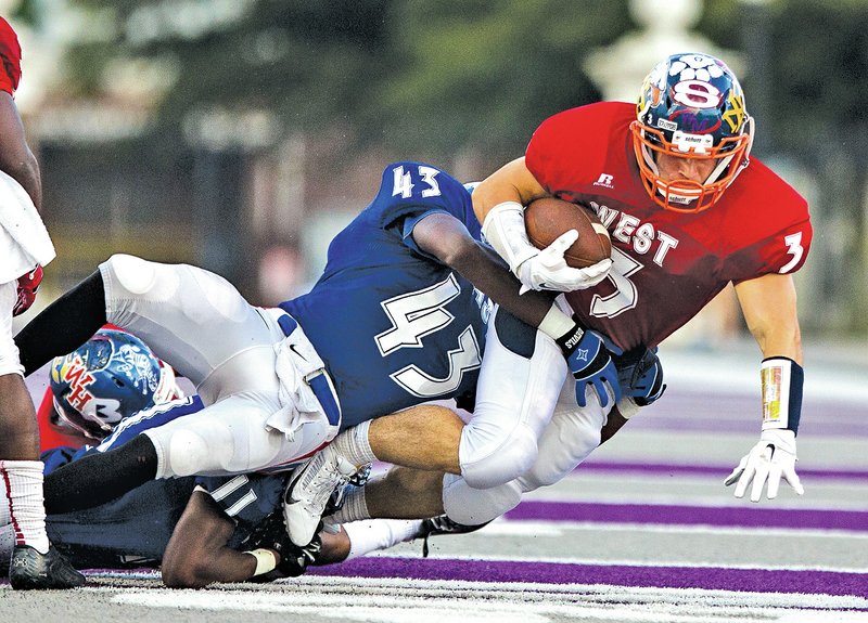  Arkansas Democrat-Gazette MELISSA SUE GERRITS Brandon Gates of the West All-Stars is taken down by East&#8217;s Demarcus Rivers during the Arkansas High School Coaches&#8217; All-Star football game at UCA in Conway.