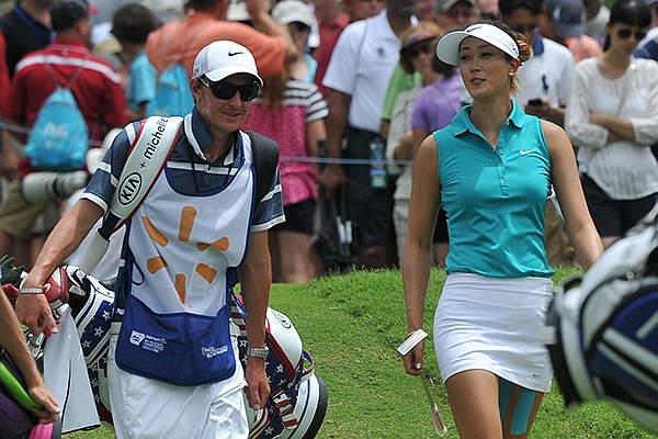 Michelle Wie talks with her caddie as they walk up the 1st fairway Friday afternoon during the first round of the Walmart NW Arkansas Championship Presented by P&G at Pinnacle Country Club in Rogers. 