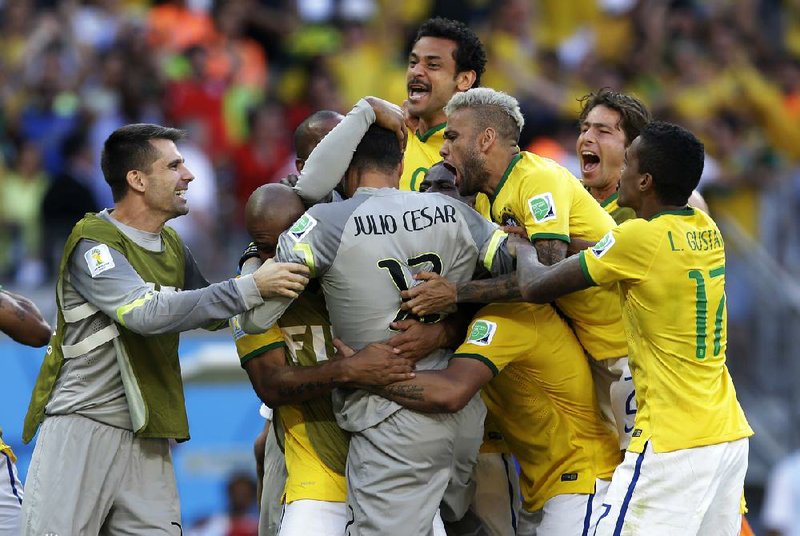 Brazilian players celebrate with goalkeeper Julio Cesar after beating Chile on penalty kicks Saturday at the World Cup to advance to the quarterfinals.