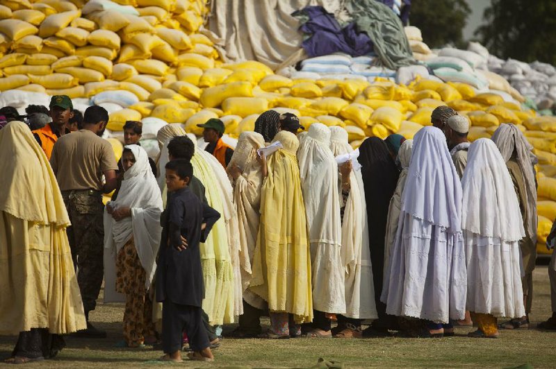 Displaced Pakistani tribal people wait for relief aid Friday in Bannu, an area officials say is ripe for the spread of polio but also a good place to immunize thousands of people.