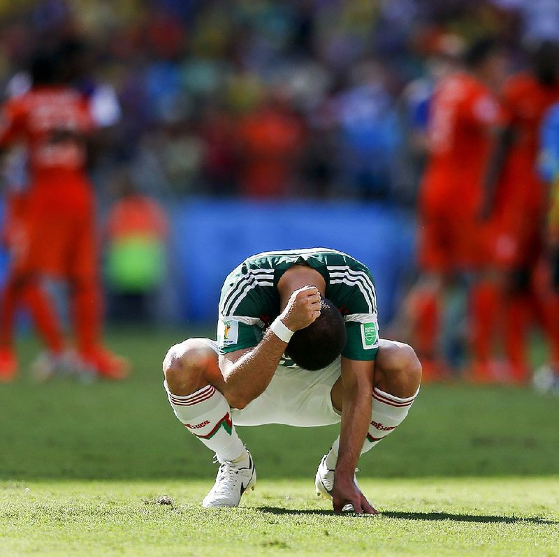 Mexico's Javier Hernandez punches the ground after the Netherlands defeated Mexico 2-1 to advance to the quarterfinals during the World Cup round of 16 soccer match between the Netherlands and Mexico at the Arena Castelao in Fortaleza, Brazil, Sunday, June 29, 2014.  (AP Photo/Eduardo Verdugo)