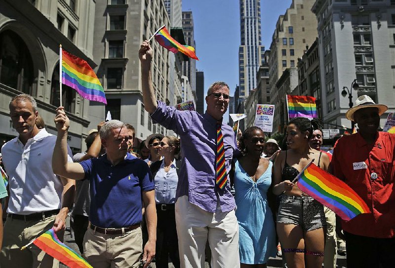 New York City Mayor Bill de Blasio, center, marches in the Gay Pride Parade in New York, Sunday, June 29, 2014. Fifth Avenue became one big rainbow on Sunday, as thousands of participants waving multicolored flags made their way down the street for New York City's annual Gay Pride march. (AP Photo/Seth Wenig)