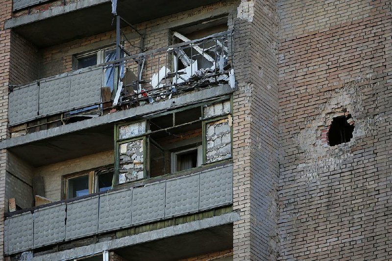 A shell hole is seen at a damaged building after shelling in the city of Slovyansk, Donetsk Region, eastern Ukraine Sunday, June 29, 2014. Residential areas came under shelling on Sunday morning  from government forces. (AP Photo/Dmitry Lovetsky)