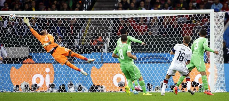 Algeria's goalkeeper Rais M’Bolhi, left, makes a save from Germany's Philipp Lahm during the World Cup round of 16 soccer match between Germany and Algeria at the Estadio Beira-Rio in Porto Alegre, Brazil, Monday, June 30, 2014. (AP Photo/Sergei Grits)