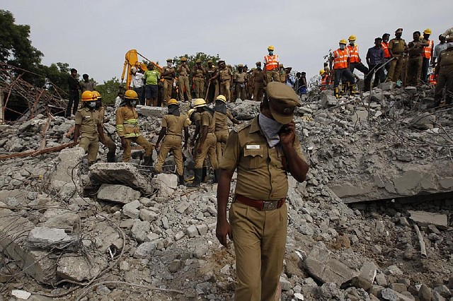 Rescuers, search for workers believed buried in the rubble of a building that collapsed late Saturday during monsoon rains on the outskirts of Chennai, India, Monday, June 30, 2014. Rescuers have pulled at least 41 people from the wreckage, even as seasonal monsoon rains impeded the search. Police said 30 other people are likely still trapped. (AP Photo/Arun Sankar K)