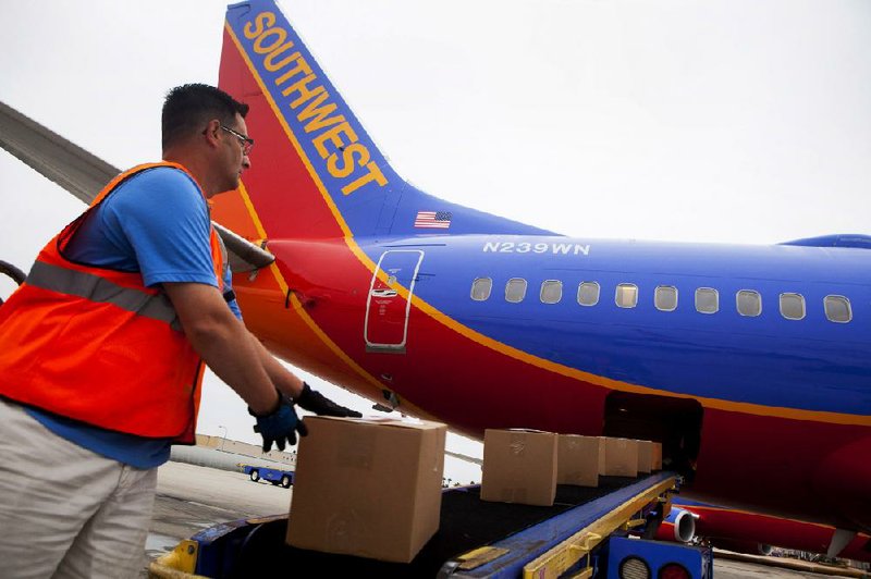 A ground crew member loads cargo onto a Southwest Airlines Co. Boeing 737 airplane at San Diego International Airport in this file photo.