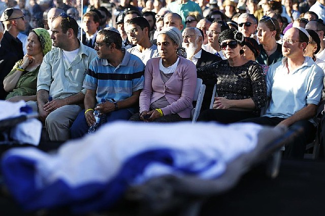 Parents of Naftali Fraenkel, 16, Eyal Yifrah, 19, and Gilad Shaar,16, the three Israeli teens who were abducted and killed in the West Bank, mourn during their sons’ joint funeral Tuesday in Modiin, Israel.