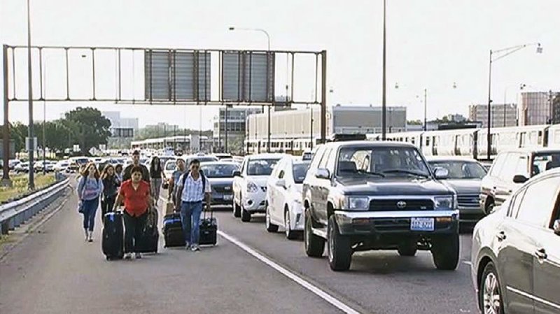 Travelers make their way toward Chicago’s O’Hare International Airport on Tuesday after traffic stalled in a sudden rain that flooded the Kennedy Expressway, the city’s main thoroughfare to the airport.