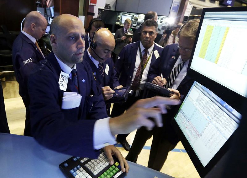 Traders gather Tuesday at the post of specialist Meric Greenbaum (foreground) on the floor of the New York Stock Exchange.