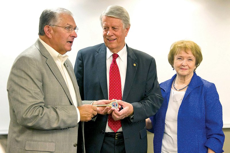 From left, Searcy Mayor David Morris presents retiring ASU-Searcy Vice Chancellor Don Harlan and his wife, Mary, a key to the city.
