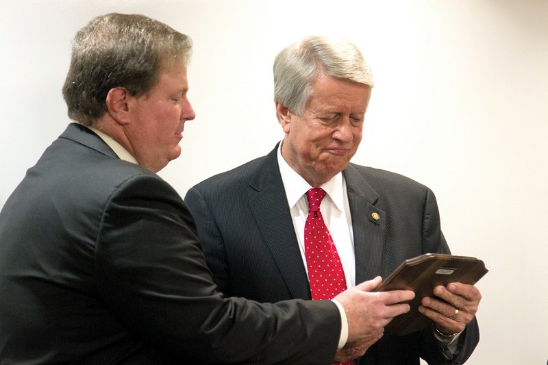 Keith Pinchback, ASU-Beebe vice chancellor for institutional advancement, left, presents retiring ASU-Searcy Vice Chancellor Don Harlan with a plaque announcing the endowment scholarship set up in 
Harlan’s name.
