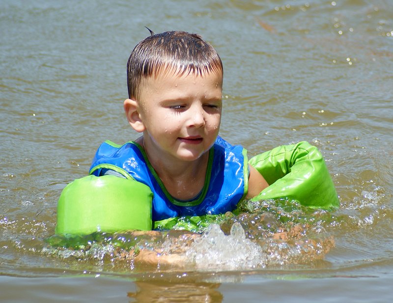 Photo by Randy Moll Jaxson Brown, 4, of Gravette, enjoys an afternoon of swimming with friends and family at Crystal Lake in Decatur on Thursday.