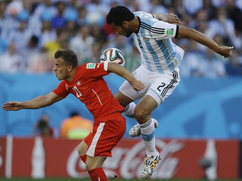 Switzerland's Xherdan Shaqiri, left, and Argentina's Ezequiel Garay go for a header during their World Cup round of 16 soccer match at the Itaquerao Stadium in Sao Paulo, Brazil, Tuesday, July 1, 2014.