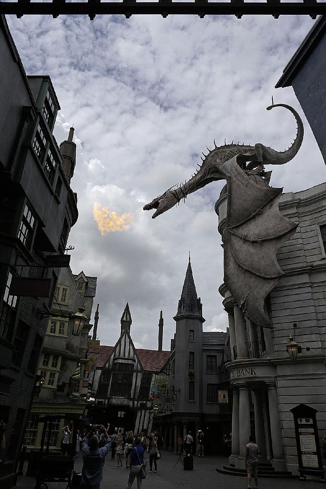 A dragon breathes fire from atop Gringotts Bank on Diagon Alley at the Wizarding World of Harry Potter at Universal Orlando, which opens Tuesday.