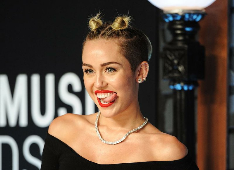 FILE - This Aug. 25, 2013 file photo shows singer Miley Cyrus at the MTV Video Music Awards in the Brooklyn borough of New York.  Cyrus says in an interview clip that she doesnít listen to the negative comments regarding her performance on the MTV Video Music Awards. The pop star says she felt she and Robin Thicke were making history with the risque performance of their hits ìWe Canít Stopî and ìBlurred Lines.î The comments were Cyrusí first since the Aug. 25 show. The clip was recorded last week and posted Tuesday morning on MTVís website. Cyrus compares the performance to that of Madonna and Britney Spears, who once kissed on air.  (Photo by Evan Agostini/Invision/AP, File)