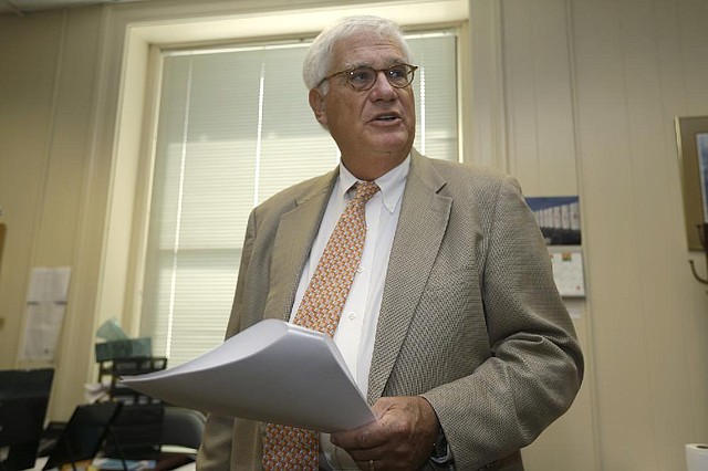 Richard Weiss, director of the Arkansas Finance and Administration Department, holds a copy of the state’s year-end revenue report Wednesday as he discusses the budget surplus.
