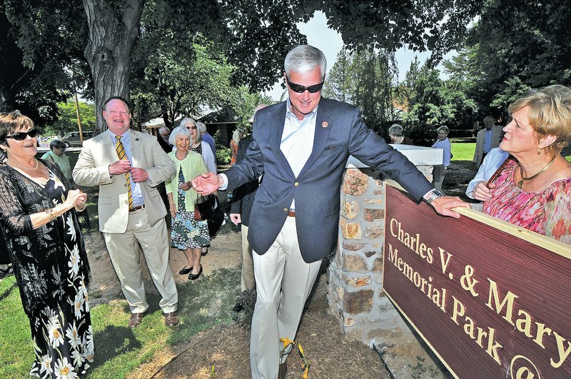 STAFF PHOTO BEN GOFF &#8226; @NWABenGoff Third District Rep. Steve Womack, R-Rogers., takes a moment to clean a smudge off of the sign for the new wheelchair-accessible park.