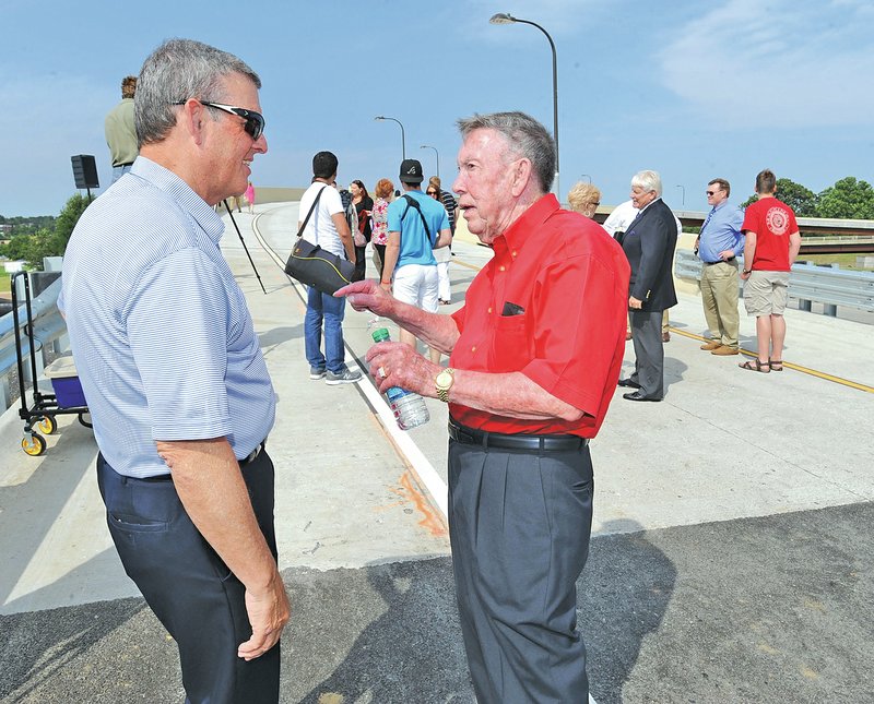 STAFF PHOTO ANDY SHUPE Dean Redford, left, of Fayetteville, speaks Wednesday with Bobby Hopper of Springdale, former director of the Arkansas Highway Commission, at a ceremony to open Fayetteville&#8217;s &#8220;flyover&#8221; that connects northbound College Avenue with the Fulbright Expressway and Mall Avenue/Shiloh Drive.