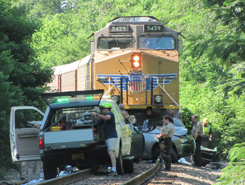 A child was killed and three people injured in a collision between a train and a vehicle.