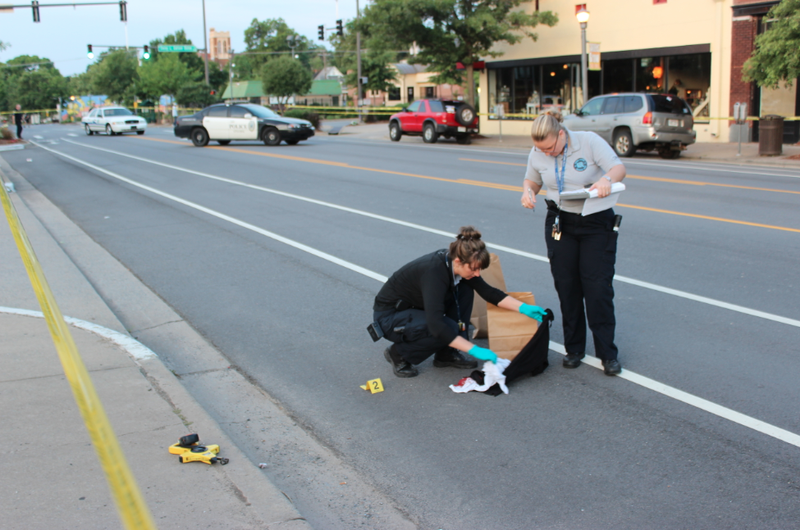 Little Rock Police Department crime scene specialists Rachel Carver, left, and Terra Lucas work the scene Thursday, July 3, 2014, of an early morning shooting on South Main Street in Little Rock.