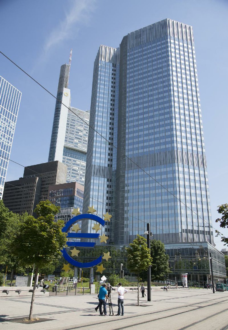 Reporters set up a video camera outside the headquarters of the European Central Bank in Frankfurt, Germany, on Thursday. Central bank President Mario Draghi reiterated that he’ll keep interest rates low as officials try to revive the region’s economy with a new round of emergency measures.