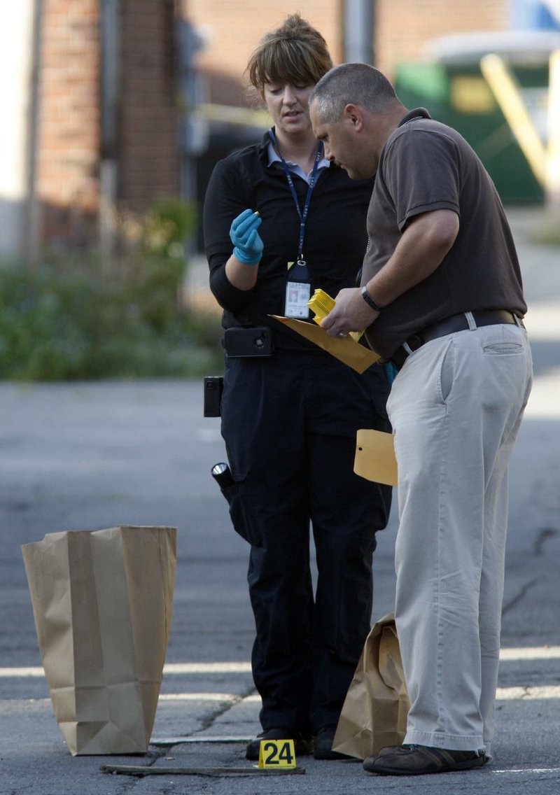 Arkansas Democrat Gazette/JEFF MITCHELL - 07/03/2014 - A Little Rock Police detective and crime scene technician examine evidence after an early morning shooting that injured two people in the alley near the intersection of Main and 13th streets in downtown Little Rock, July 3, 2014. 