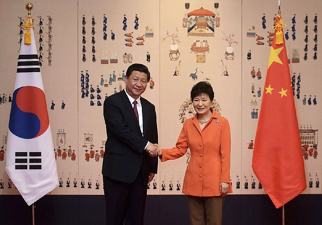 China's President Xi Jinping, left, and his South Korean counterpart Park Geun-hye shake hands prior to their summit meeting at the Blue House in Seoul Thursday, July 3, 2014. With a single meeting Thursday, the leaders of China and South Korea simultaneously snubbed North Korea, bolstered their already booming trade relationship and gave the U.S. and Japan a look at Beijing's growing influence south of the Korean Demilitarized Zone. (AP Photo/Ed Jones, Pool)