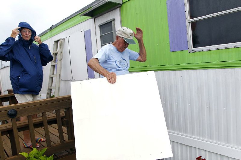 Jacque, left, and Jesse Carawan from Plymouth, NC brace against the stiff winds as they secure their beach trailer in anticipation of the coming of Hurricane Arthur on Atlantic Beach  Thursday,  July 3, 2014.  They just came down to secure the trailer from the storm; they were going home to Plymouth after they finished.  Hurricane Arthur is expected to have its greatest impact on the North Carolina coast late Thursday night/early Friday morning. (AP Photo/The News & Observer, Chris Seward)