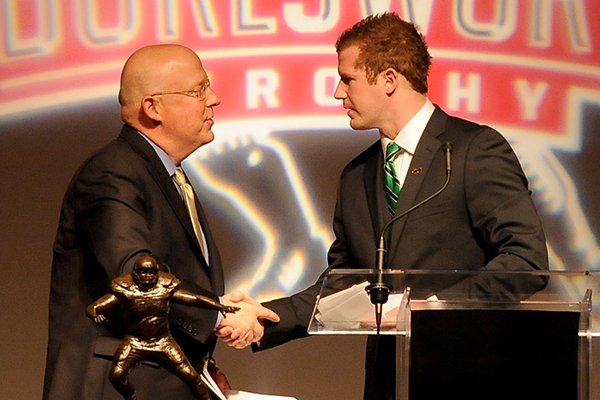Matt McGloin, senior quarterback from Penn State, shakes hands with Chuck Barrett after accepting the Brandon Burlsworth Trophy Monday, Dec. 3, 2012 during a ceremony at the Springdale Holiday Inn Convention Center in Springdale.