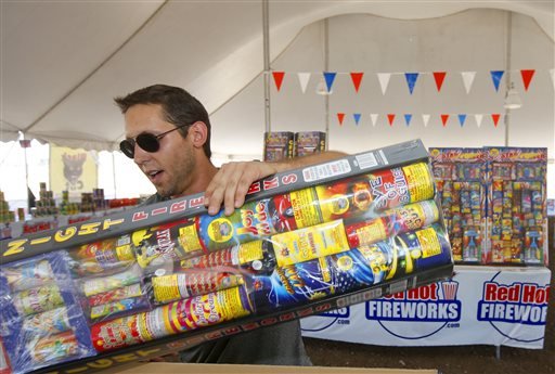 In this photo taken on Wednesday, July 2, 2014, Brian Herrman, a co-owner of Red Hot Fireworks in Phoenix, puts out new items on the shelves as sales of fireworks have been brisk at the store. Although Phoenix has gone a full 120 days without any measurable precipitation there has not been any serious effort in the drought-stricken states to restrict fireworks. Arizona actually loosened its restrictions this year and allowed residents of the two most populated cities to set off fireworks around Independence Day. 
