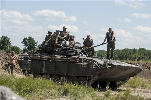 Ukrainian troops atop an APC at a checkpoint near Slovyansk, eastern Ukraine, Saturday, July 5, 2014. Ukraine's forces claimed a significant success against pro-Russian insurgents on Saturday, chasing them from one of their strongholds in the embattled east of the country. Rebels fleeing from the city of Slovyansk vowed to regroup elsewhere and fight on. 