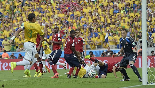 Brazil's Thiago Silva, left, scores the opening goal during the World Cup quarterfinal soccer match between Brazil and Colombia at the Arena Castelao in Fortaleza, Brazil, Friday, July 4, 2014. (AP Photo/Manu Fernandez)