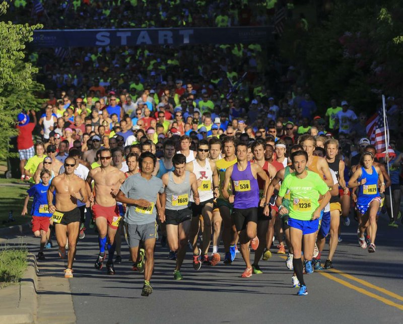  Arkansas Democrat-Gazette/STATON BREIDENTHAL --7/4/14-- Runners leave the starting line to begin the Firecracker Fast 5k Saturday morning.