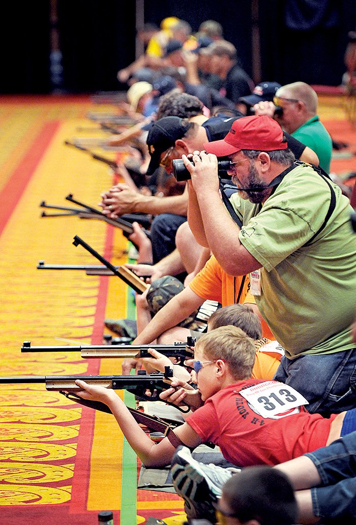 Tex Manuel II, coach of the Bull Masters from northeast Kansas, helps shooters Saturday during the 49th annual Daisy National BB Gun Championship Match held in Rogers.