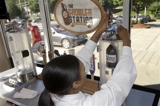 In this July 3, 2014 photo, a woman fills a bottle called a growler with beer from a local microbrewery at a Little Rock, Ark., convenience store. A recent change in Arkansas’ liquor laws allows beer drinkers to enjoy a broader variety of beverages at home. 