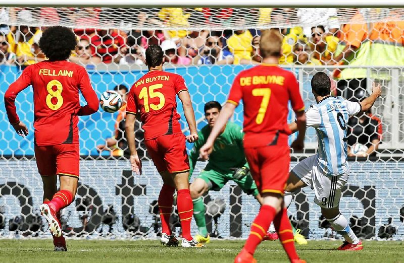 Argentina’s Gonzalo Higuain (right) kicks the ball by Belgium goalkeeper Thibaut Courtois to score his team’s only goal in its victory, which moved Argentina into the semifinals.