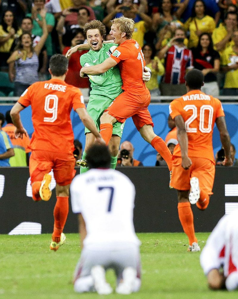 Netherlands goalkeeper Tim Krul (center) celebrates with teammates Dirk Kuyt (second from right), Robin Van Persie (9) and Georginio Wijnaldum (20) as a dejected Christian Bolanos of Costa Rica watches after losing 1-0 on penalty kicks in the quarterfinals Saturday.