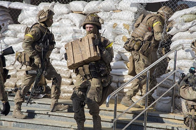 Ukrainian soldiers carry captured weapons out of rebel headquarters Saturday in Slovyansk after surrounding the city Friday night and driving out the pro-Russia forces.
