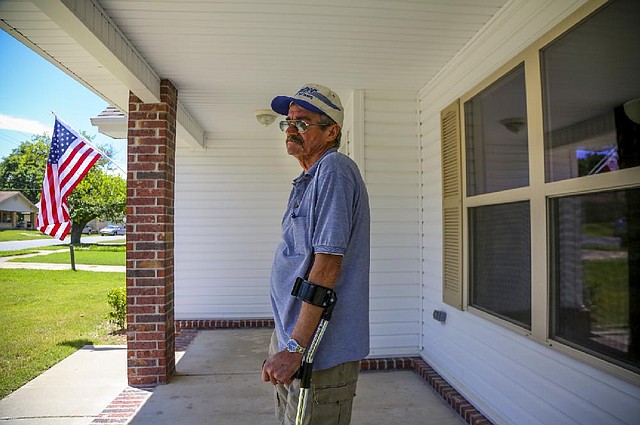 Veteran John Kendall stands on the front porch of his new home Wednesday in North Little Rock.