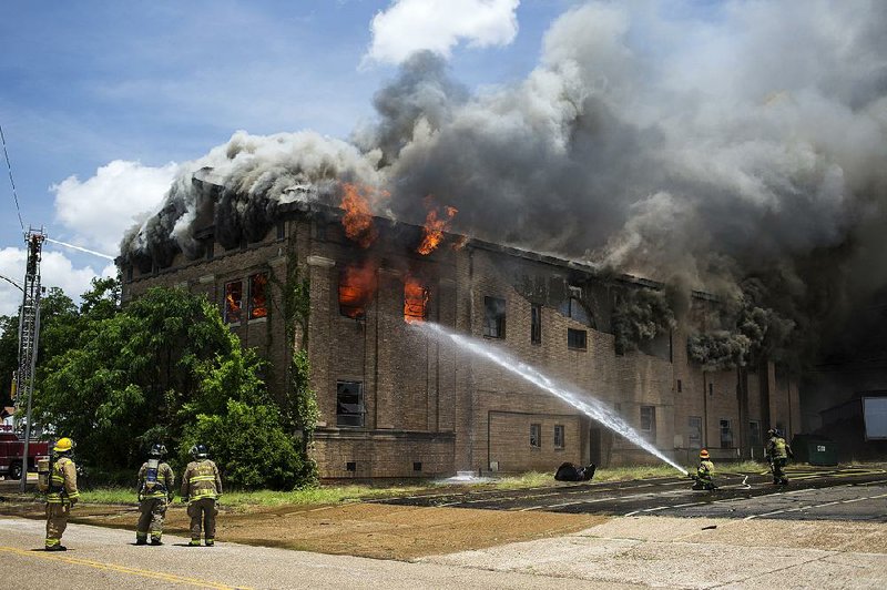 Staff photo by Curt Youngblood
Firefighters from Texarkana, Arkansas and Texarkana, Texas fight a fire in the old Masonic Lodge building on Monday afternoon. The fire appeared to have started in the top floor of the building.
