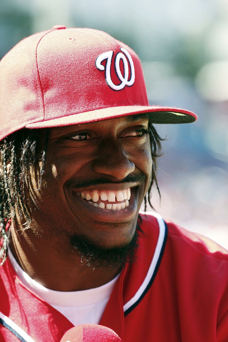 Washington Redskins quarterback Robert Griffin III smiles during an interview before a baseball game between the Washington Nationals and the Chicago Cubs at Nationals Park, Saturday, July 5, 2014, in Washington. (AP Photo/Alex Brandon)