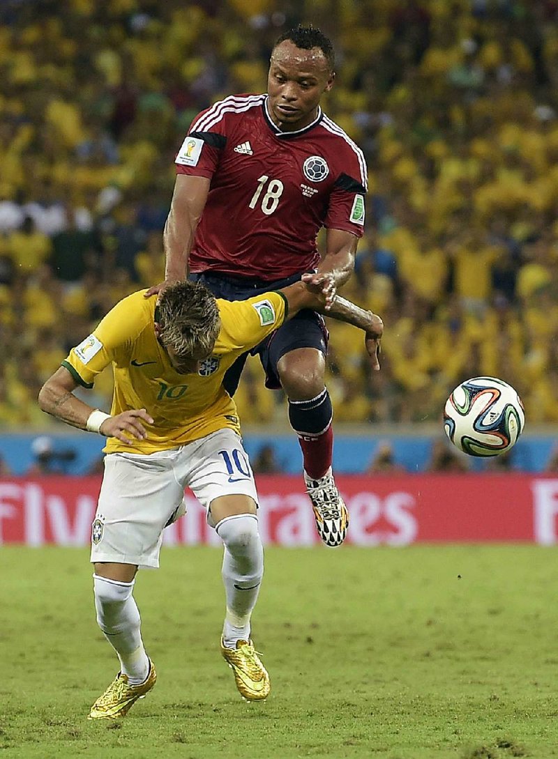 Brazil's Neymar is fouled by Colombia's Juan Zuniga during the World Cup quarterfinal soccer match between Brazil and Colombia at the Arena Castelao in Fortaleza, Brazil, Friday, July 4, 2014. Brazil's team doctor says Neymar will miss the rest of the World Cup after breaking a vertebrae during the team's quarterfinal win over Colombia. (AP Photo/Manu Fernandez)