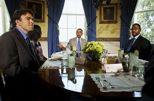 President Barack Obama, center, speaks about education during a lunch meeting with teachers, Monday, July 7, 2014, in the Blue Room of the White House in Washington. From left are, Justin Minkel of Arkansas; Leslie Ross of Greensboro, N.C.; Obama, and Dwight Davis of Washington. (AP Photo/Jacquelyn Martin)