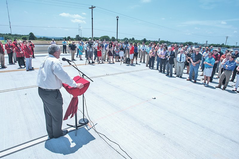 STAFF PHOTO ANTHONY REYES Doug Sprouse, Springdale mayor, addresses members of the community Monday for the opening of the Don Tyson Parkway overpass and interchange in Springdale.