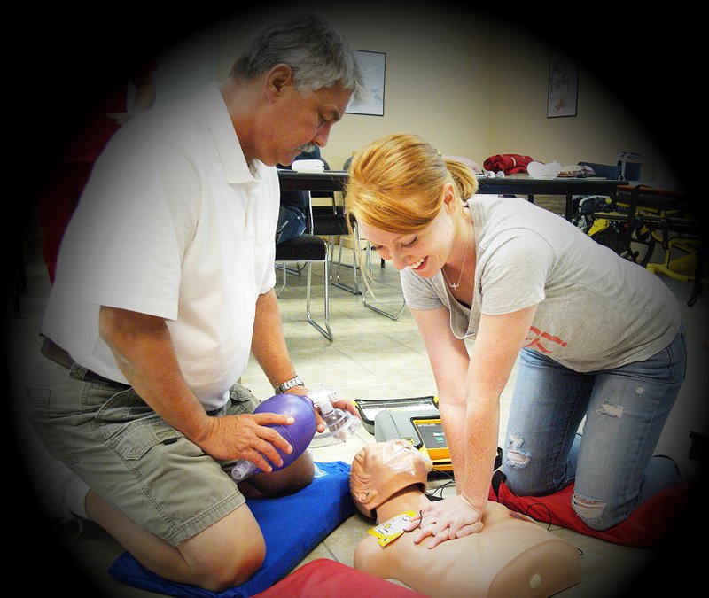 Photo by Randy Moll Carmen Puryear (right), of Gentry, practices CPR skills in a class at Petra Allied Health in Springdale on July 2. The class was learning to use a defibrillator along with cardiopulmonary resuscitation skills.
