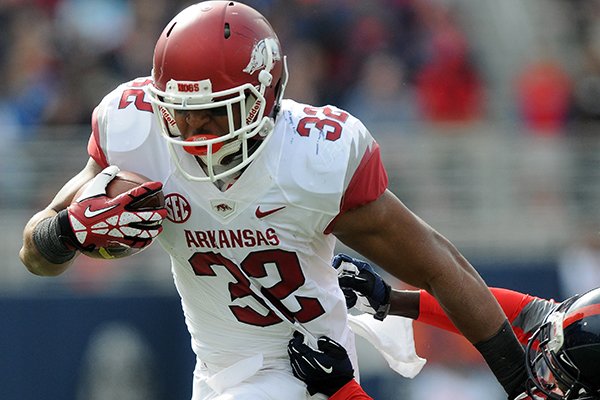 Arkansas' Jonathan Williams, left, slips past a defender Saturday, Nov. 9, 2013, during the second quarter of the game against Ole Miss at Vaught-Hemingway Stadium in Oxford, Miss.