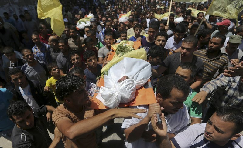 Palestinians carry bodies of seven people killed in a strike during their funeral in Khan Younis refugee camp in the southern Gaza Strip, Wednesday, July 9, 2014. Israel stepped up its offensive on the Hamas-run Gaza Strip on Wednesday, pummeling scores of targets and killing over a dozen of people as Israeli leaders signaled a weeks-long ground invasion could be quickly approaching. Hamas official Musheer al-Masri said Israel had “crossed all the red lines” and warned that Hamas would strike back fiercely. 