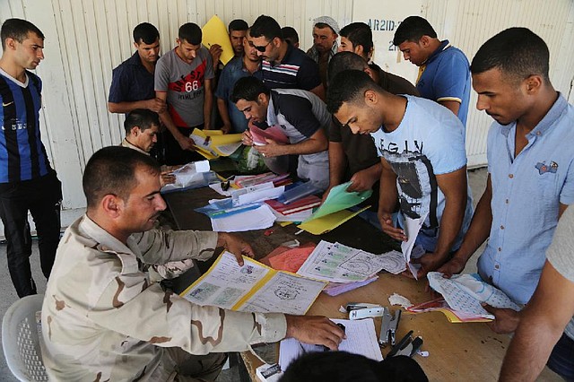 Iraqi men check in at the main army recruiting center in Baghdad on Wednesday as they volunteer for military service. Authorities are urging citizens to help battle insurgents.